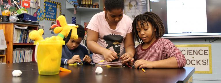 Three students creating circuits