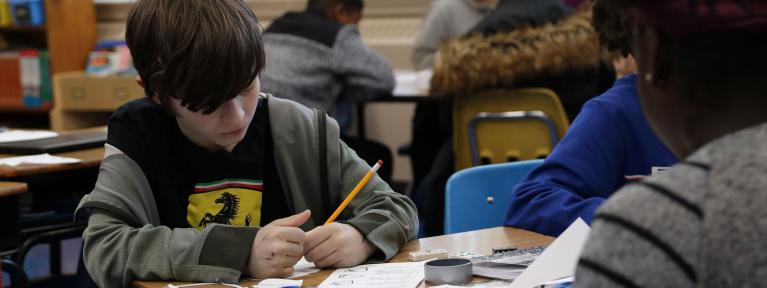 Student at desk writing