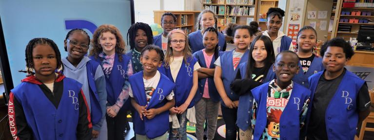 Students in library wearing leadership vests