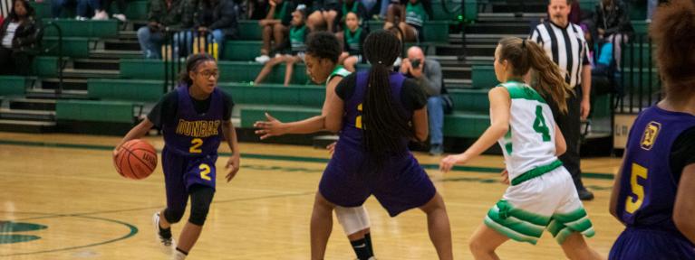 Basketball player dribbling around a screen