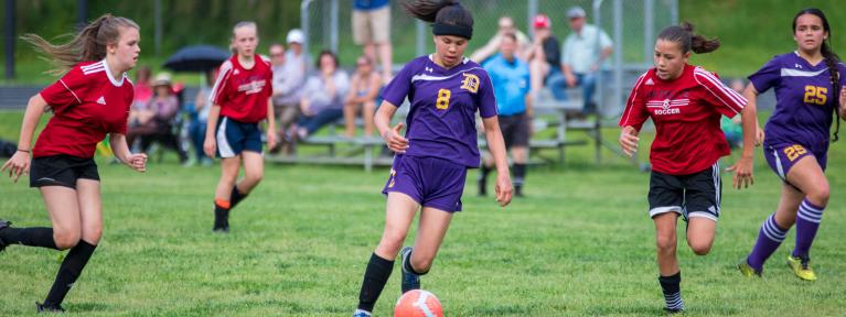 Girls playing soccer on field