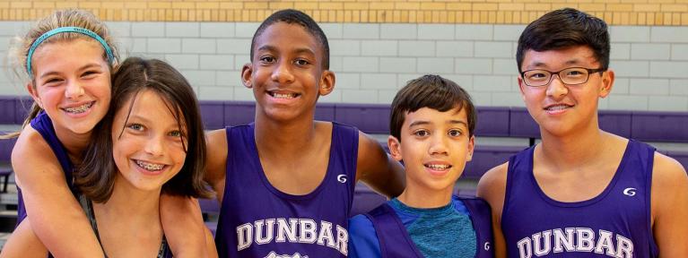 Five students smiling wearing Dunbar shirts