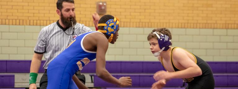 Two wrestlers at start of match with referee