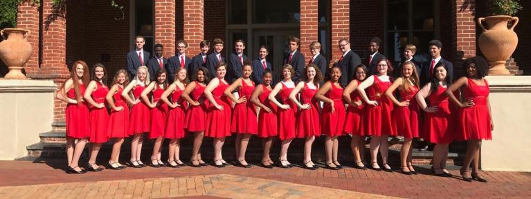 Acapella group dressed up standing in front of building