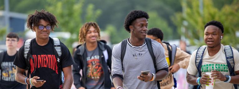 High school students with backpacks walking into school