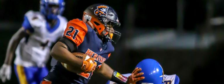 Football player stiff arming a defender