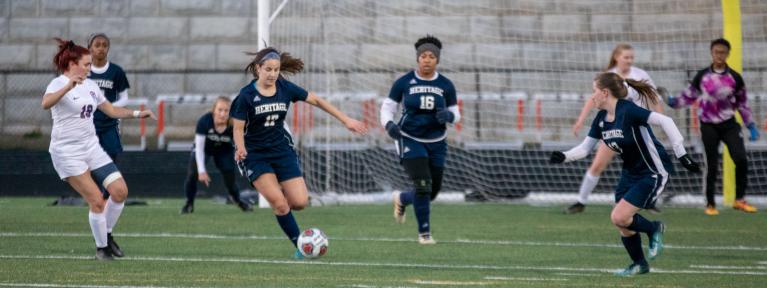 Girls soccer players running on field