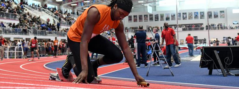 Track runner lining up at indoor event