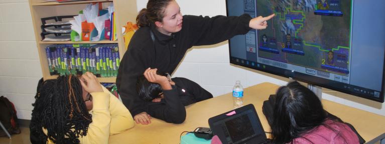 Students standing pointing at screen