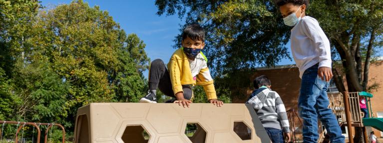 Pre-K students on playground equipment