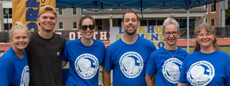 Administrators and faculty at a community event in matching shirts
