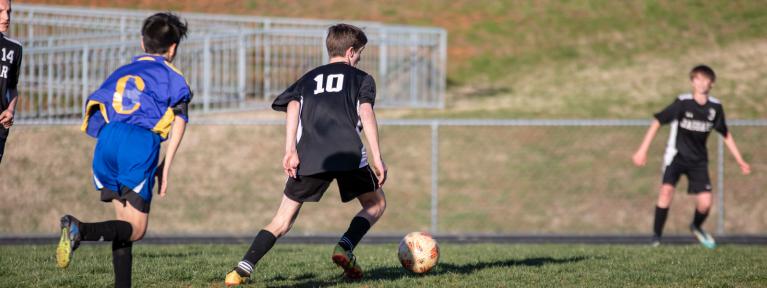 Boys playing soccer on field