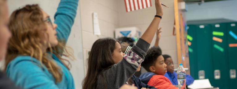 Students in class raising hands