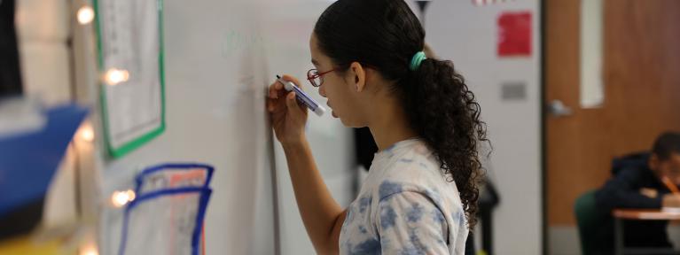 Student writing on whiteboard