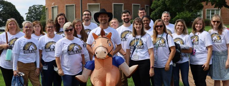 School staff in matching Virtual Academy shirts standing outside