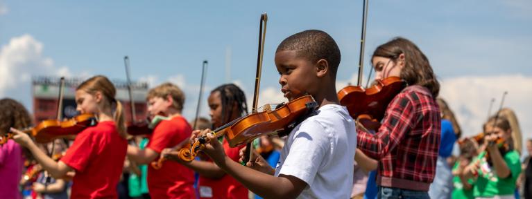 Boy playing violin outside