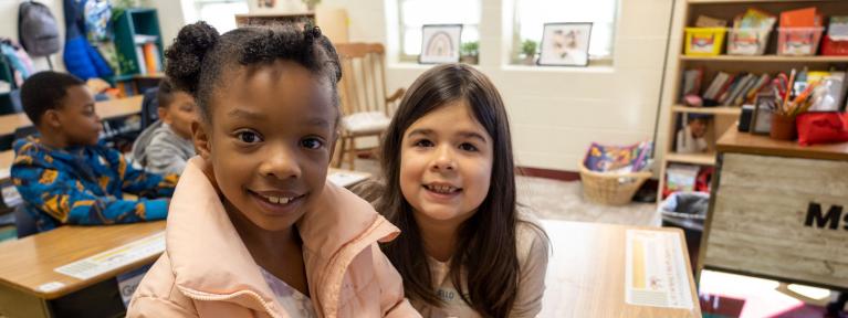 Two students smiling in classroom