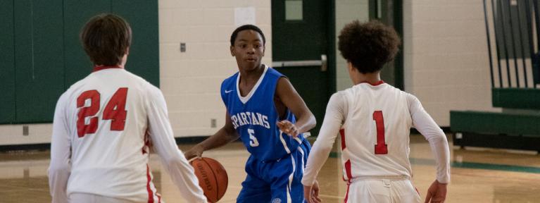 Basketball player looking past two defenders