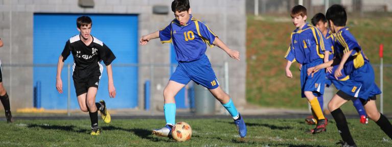 Boys playing soccer on field