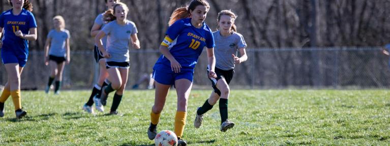 Girls playing soccer on field