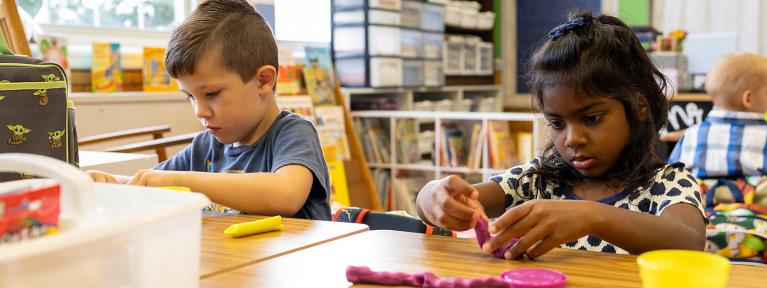 Students at desks working with Play-Doh
