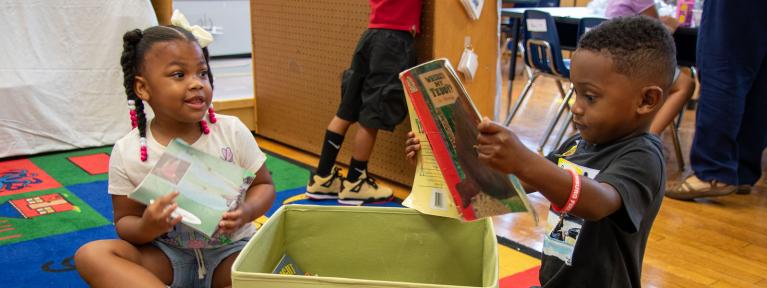 Two pre-k students looking at books
