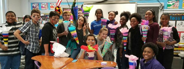 Group of students holding crafts in foreign language classroom